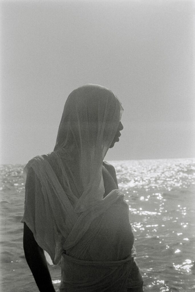 Fatou Alhya Diagne in a traditional melhfa photographed by the water in Hammamet, Tunisia