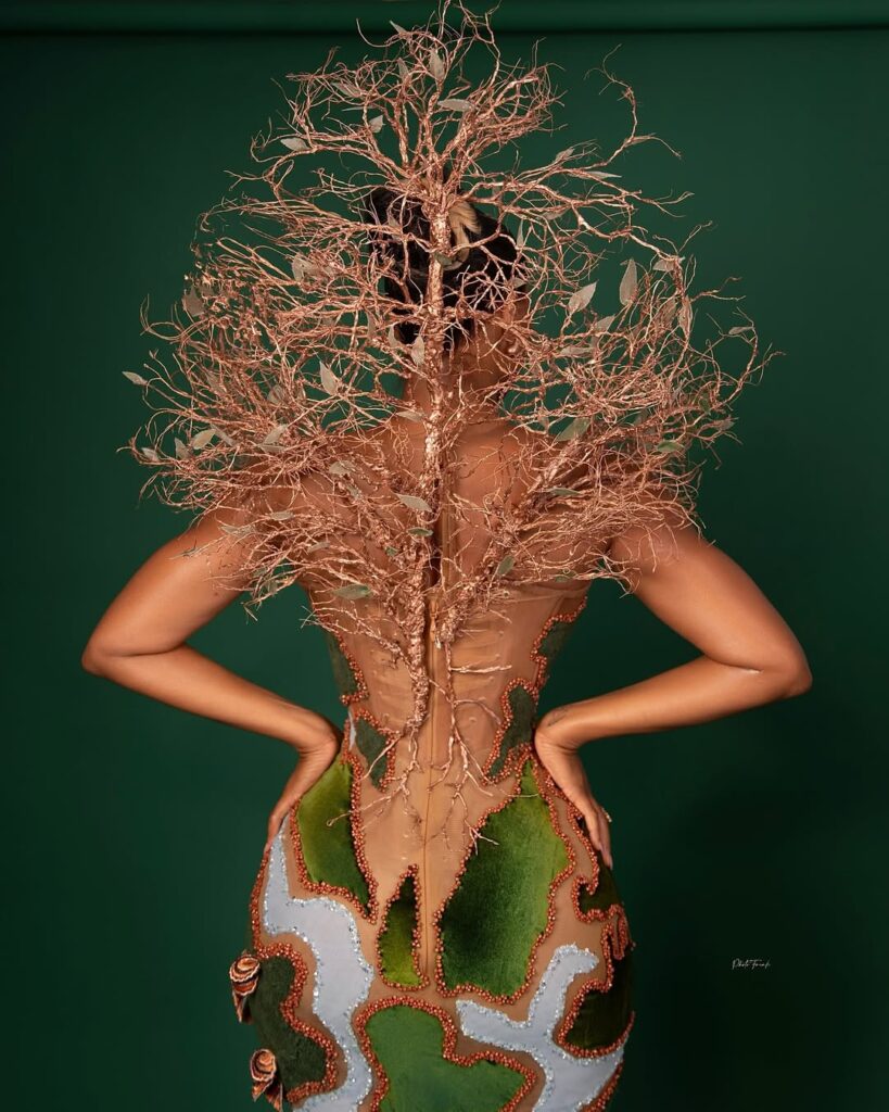 Back view of Osas Ighodaro wearing a custom Veekee James gown featuring a sculptural corset and an intricate tree-like design that extends dramatically from the bodice.