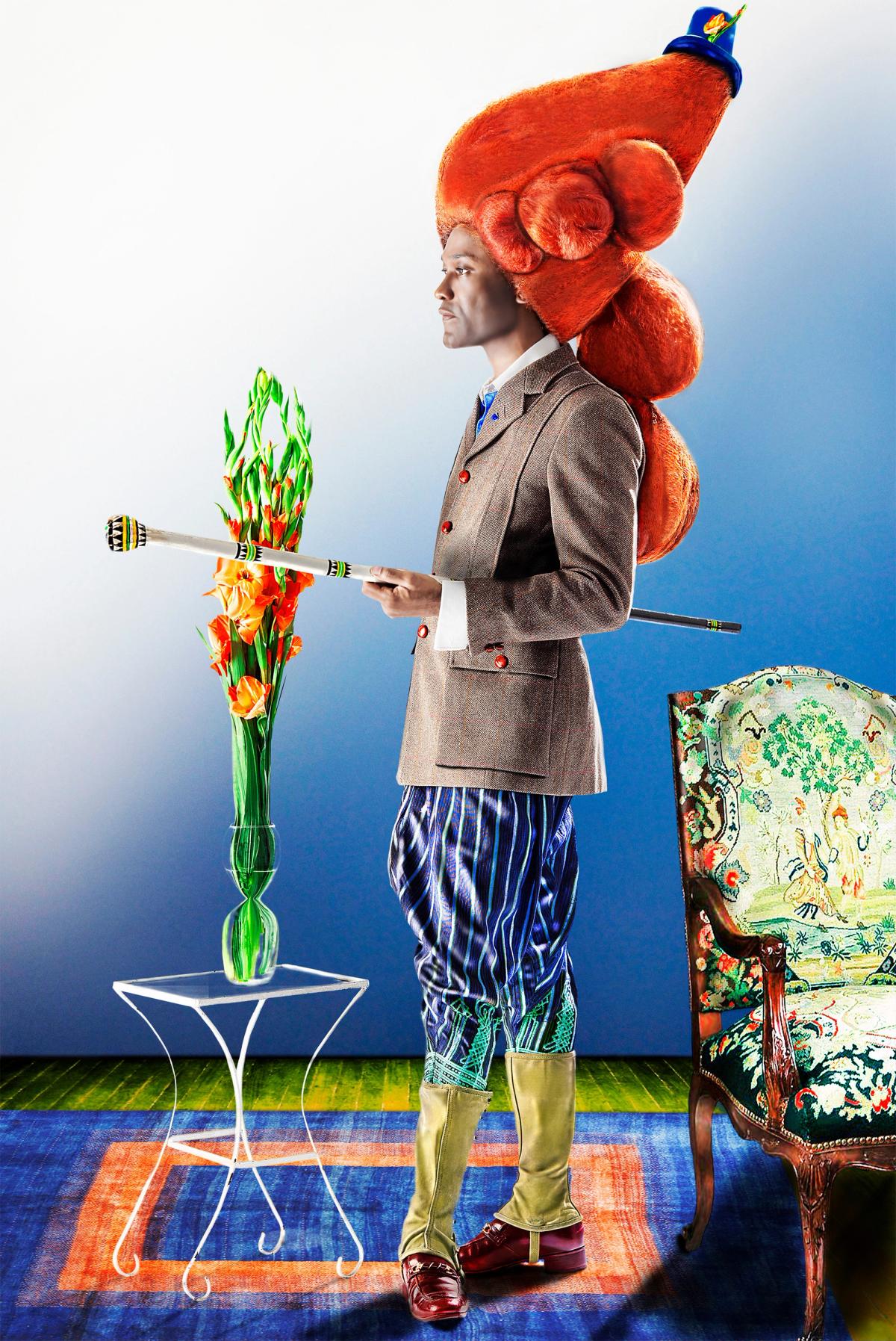 A person in a stylish brown suit with a flamboyant red hat holds a cane, standing beside a table with flowers. The setting exudes vibrancy and elegance.