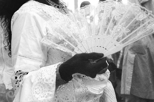 Woman holding lace fan, traditional attire