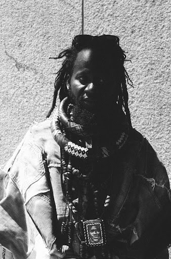 Person wearing layered clothing and accessories.