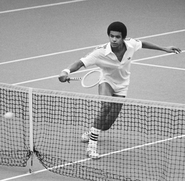 Black-and-white action shot of Yannick Noah playing in the 1979 Davis Cup against the Netherlands.