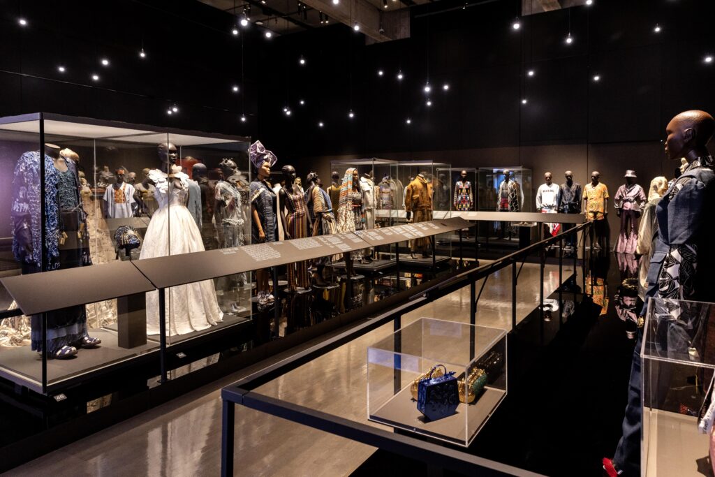 Africa Fashion Arrives in Montreal: A Global Conversation Continues 6 Wide shot of the final gallery showing rows of mannequins in diverse silhouettes and materials under star-like ceiling lights.