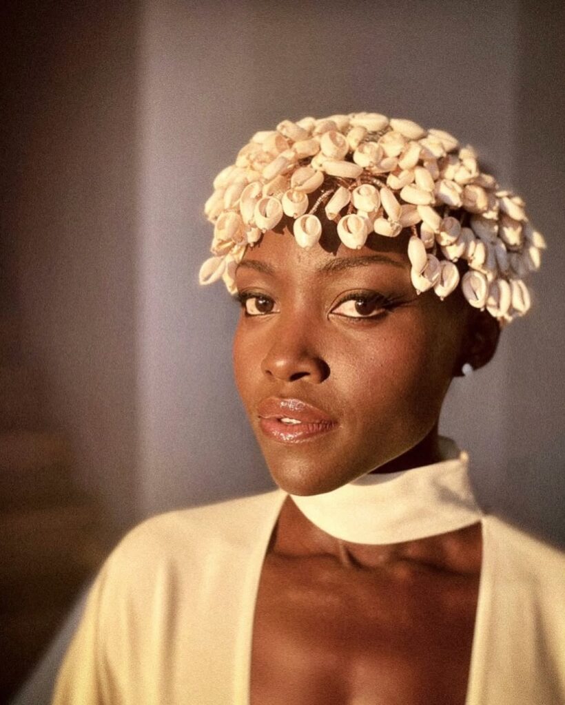African Ritual Aesthetics in the Age of Luxury Fashion 6 Lupita Nyong'o in Lafalaise Dion's Queen of Cowries V3 cowrie shell headpiece against a warm backdrop