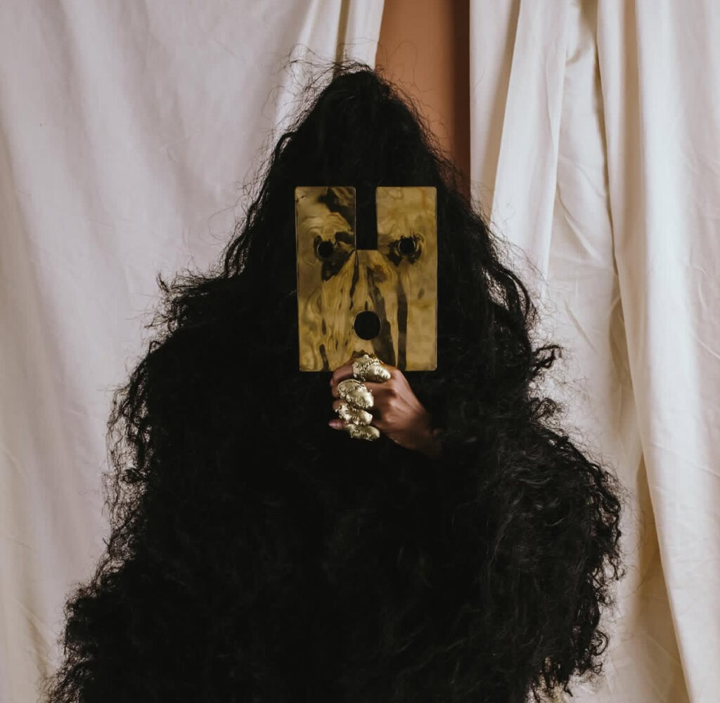 African Ritual Aesthetics in the Age of Luxury Fashion 3 Figure covered in long black fringe with a gold mask, from Bubu Ogisi's SS24 Shadows collection
