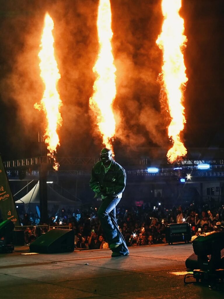 Flame jets firing from a concert stage above the crowd at a night event