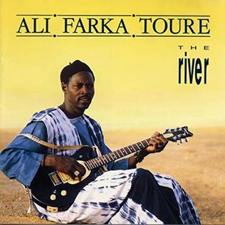 The Blues That Never Left Africa 9 Ali Farka Touré album cover for The River showing the Malian guitarist seated with guitar against Sahara desert landscape