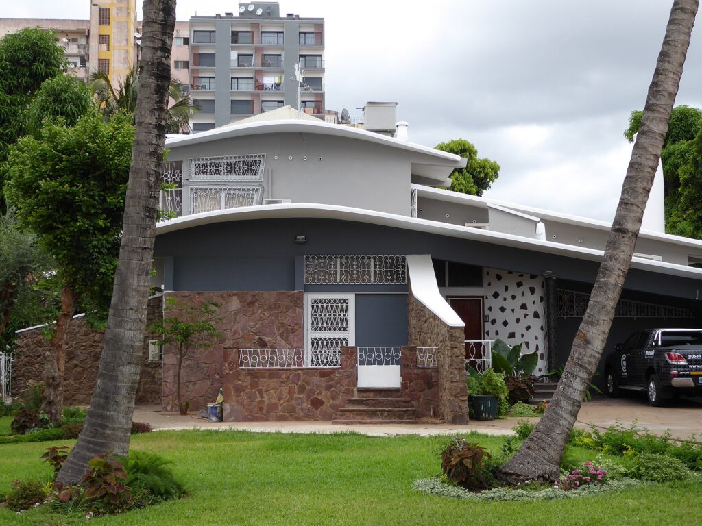 Villa with distinctive wing-shaped roofs surrounded by palm trees. Casa Leite Martins, also known as Casa Avião or Airplane House, by Pancho Guedes, 1951–52, Maputo, Mozambique.