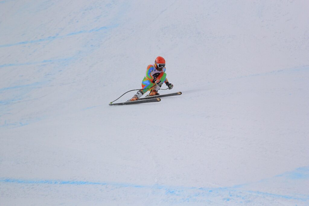 Alpine skier Shannon Abeda racing down a snowy downhill course