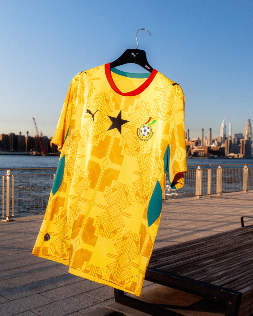 The yellow PUMA Ghana 2026 World Cup away jersey hanging outdoors at the kit launch event on the Brooklyn waterfront.