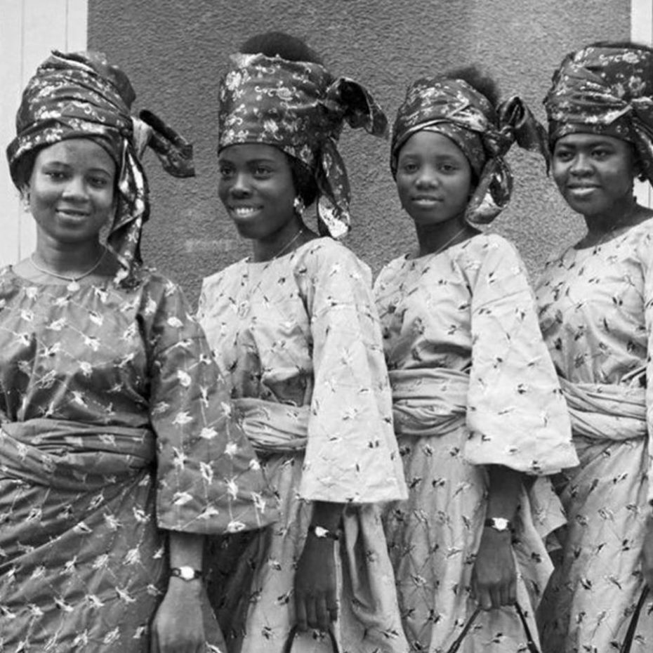 Why the Wrapper Remains West Africa's Undecolonized Garment 2 Archival black and white photography by J.D. 'Okhai Ojeikere featuring four West African women in traditional Iro and Gele (wrapper and head tie) sets.
