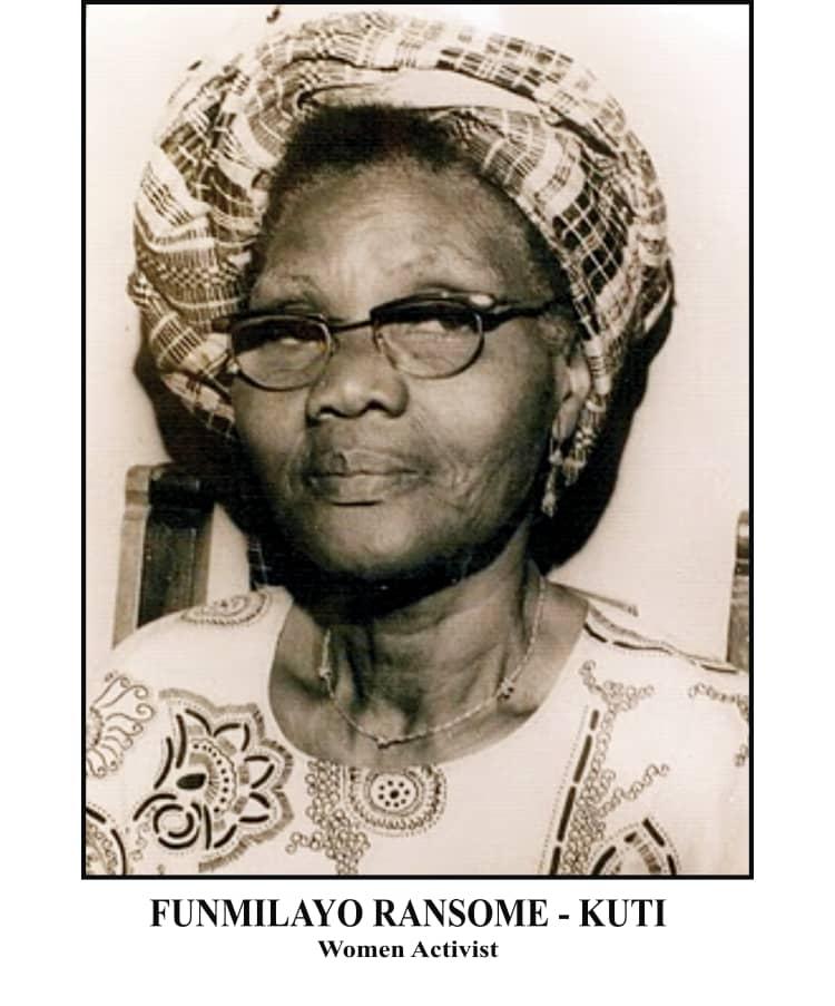 The Women Who Built the Revolution 3 Black and white portrait of Funmilayo Ransome-Kuti wearing a traditional Nigerian headtie (gele) and glasses, looking directly at the camera.