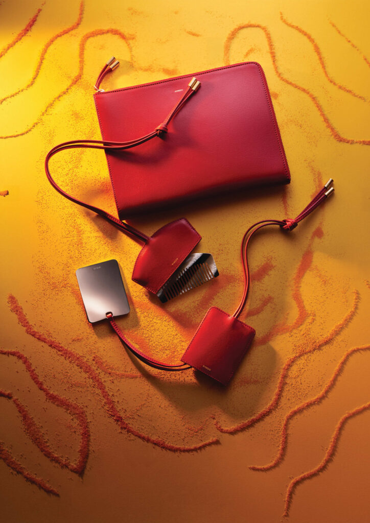 Byredo luxury leather accessories and handbags in vibrant red, photographed by Romain Lenancker for the Bal d’Afrique campaign.