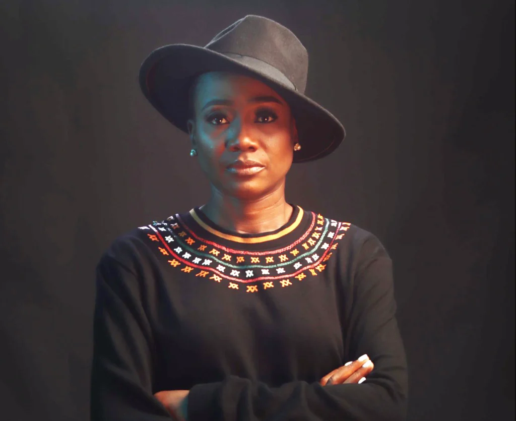 Kibonen Nfi, founder of KIBONEN wearing hat and sweater.