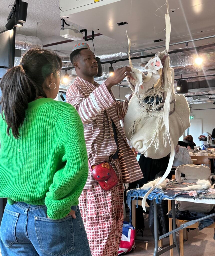 Inside Central Saint Martins’ Makers Camp: West African Makers in Focus 3 Nigerian designer Peter Acha and student Yahvi Duggal examining a white textile piece hanging in a studio during the Central Saint Martins Makers Camp.