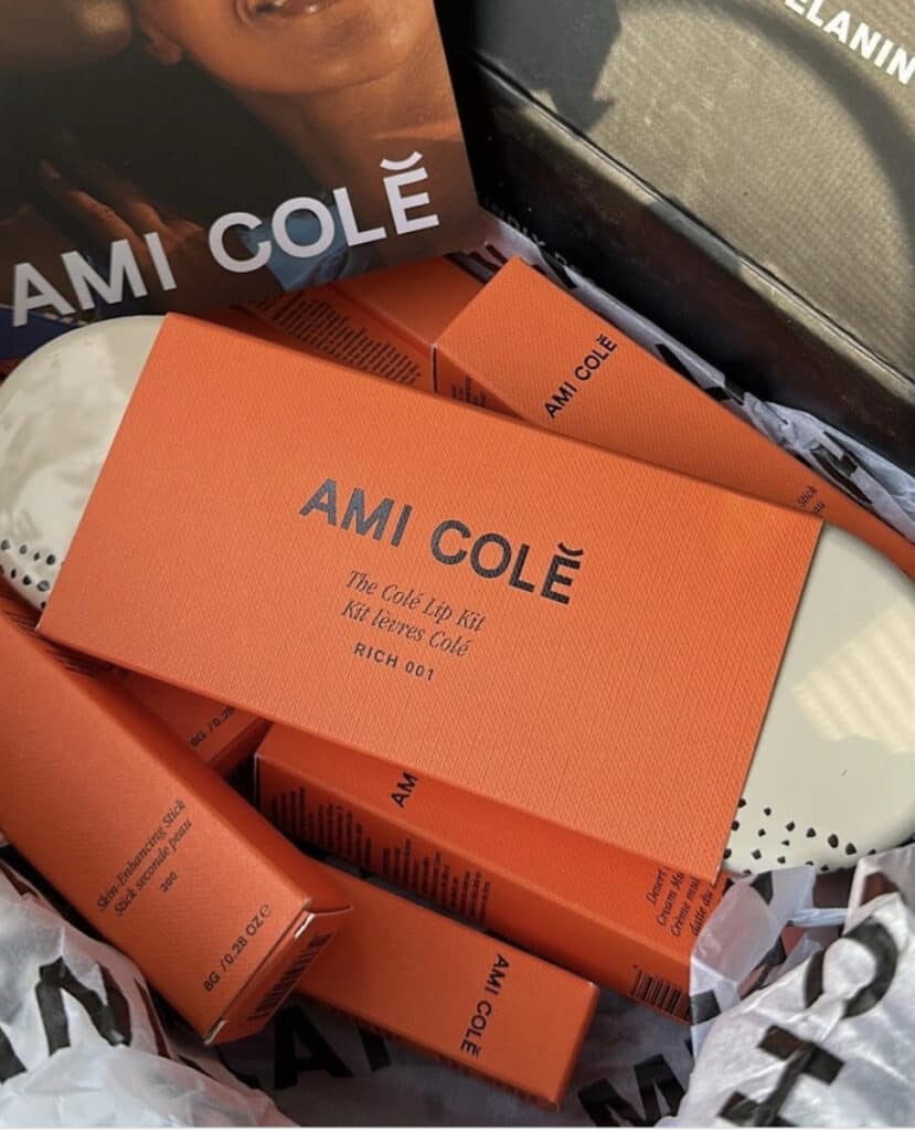 Ami Colé beauty products in signature orange packaging, representing the successful scaling of a Black-owned beauty brand into major retailers.