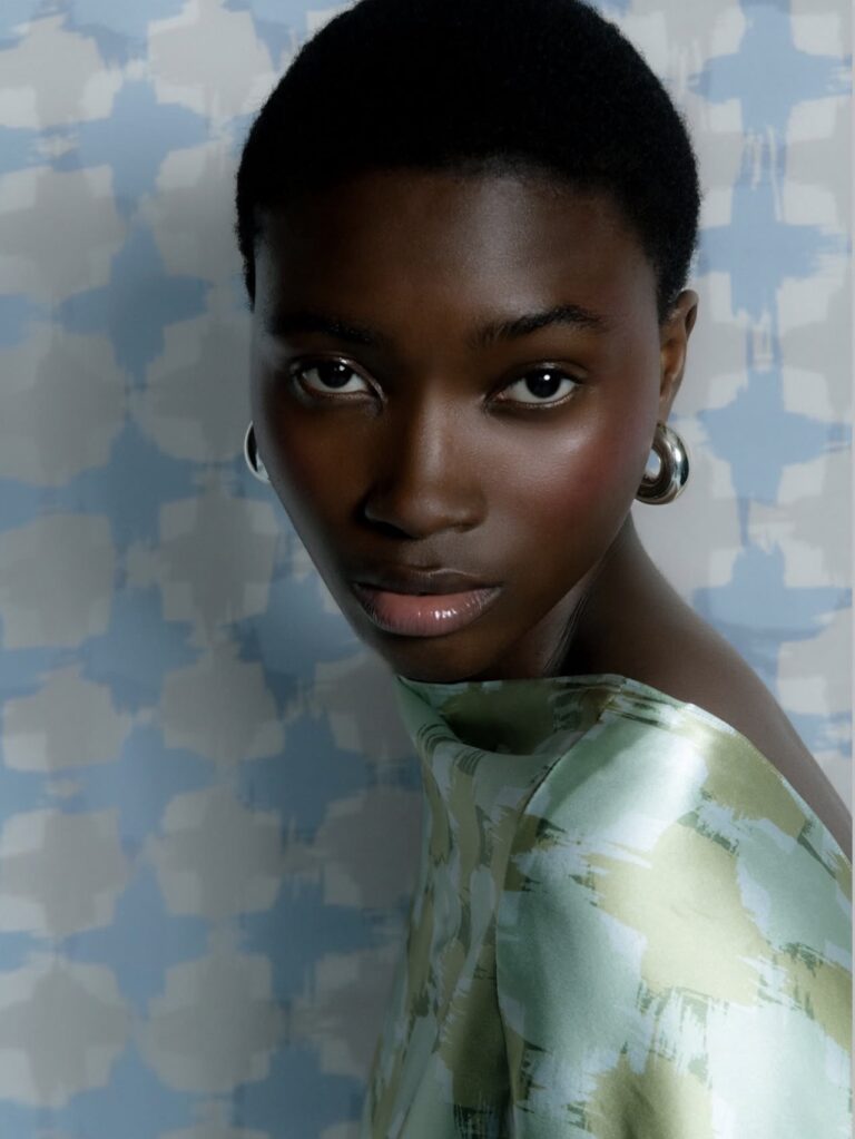 Amayi Archive One: model in hand-painted abstract print top against blue brushstroke backdrop, Joanna Masiyiwa debut collection