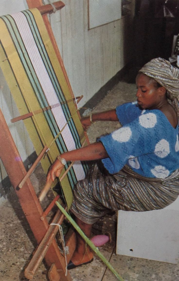 A Yoruba woman weaves Aso-Oke cloth on an upright narrow-band loom in a workshop in Iseyin, Nigeria, the historic center of Aso-Oke production.