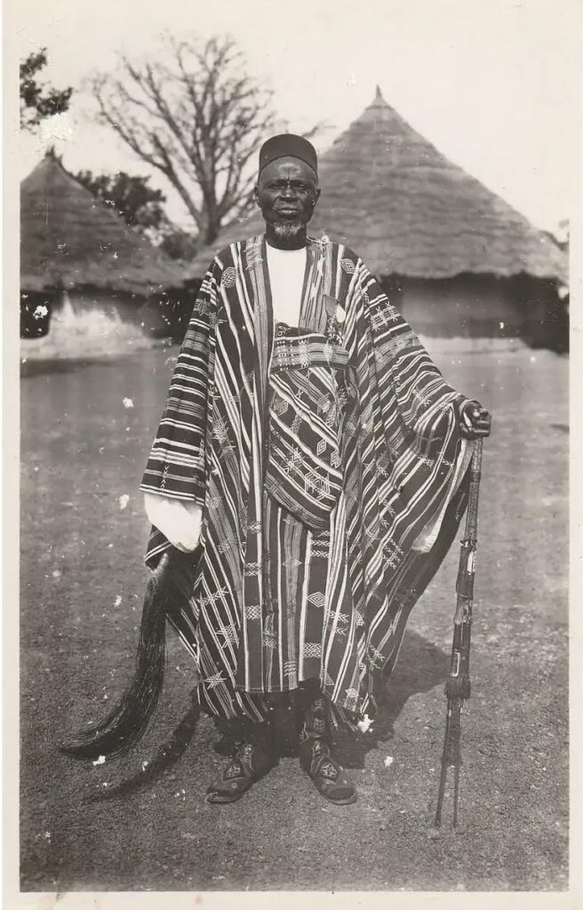 Vintage 1910 portrait of Chief Malike of Haute-Guinée wearing a traditional Mande woven garment, reflecting historical West African textile systems.
