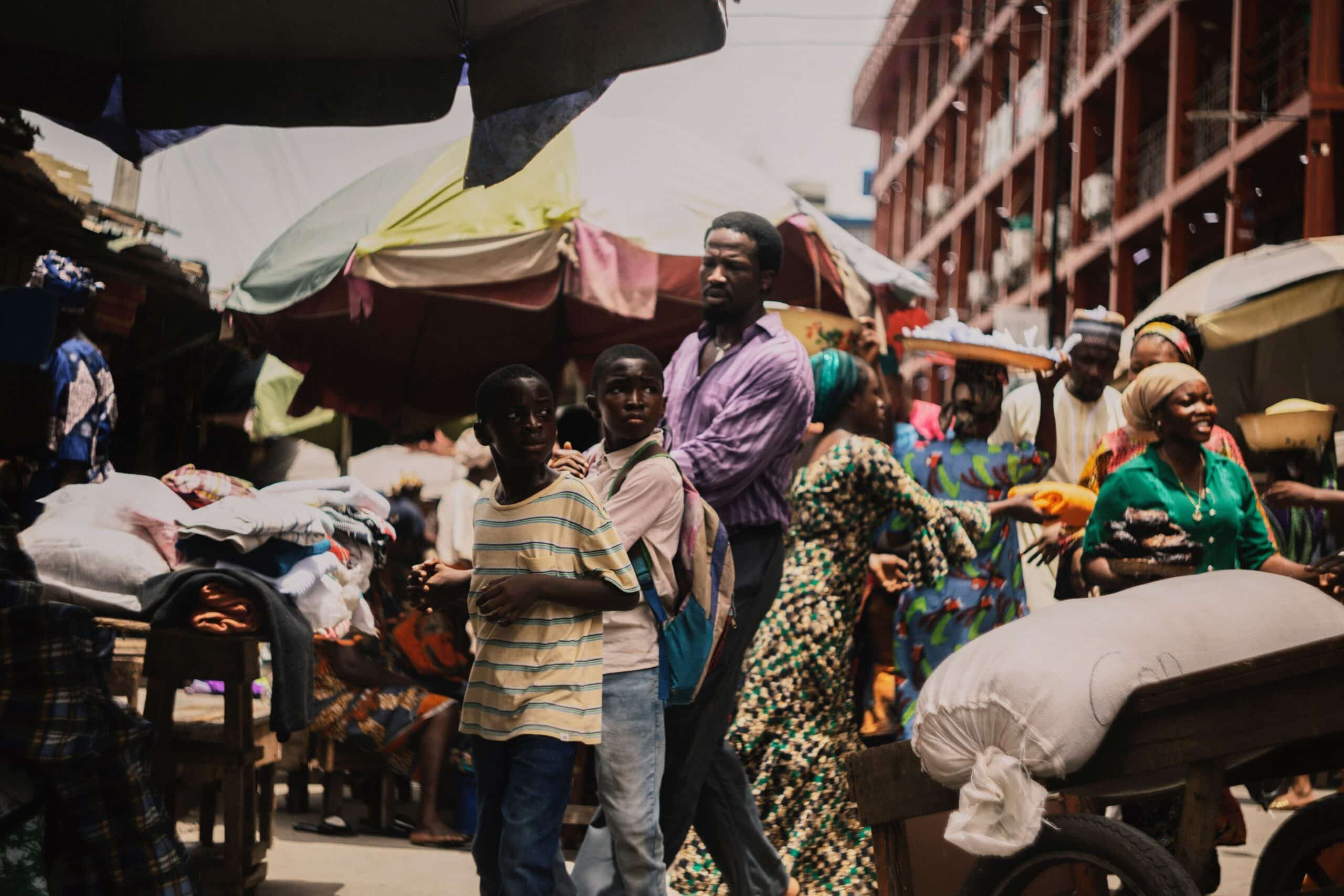 A wide shot of a Lagos street captured on 16mm film from My Father’s Shadow, highlighting the authentic, mundane beauty of everyday life in Nigeria.