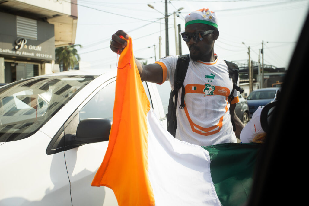 The Jersey Economy: Why Africa Is the Most Valuable Untapped Market in Sports Merchandise 6 An African football supporter celebrating on the street with a Côte d'Ivoire national flag.
