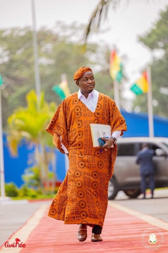 Guinean Minister Moussa Moise Sylla wearing a Forêt Sacrée textile, a traditional handwoven and plant-dyed garment from Guinée Forestière.