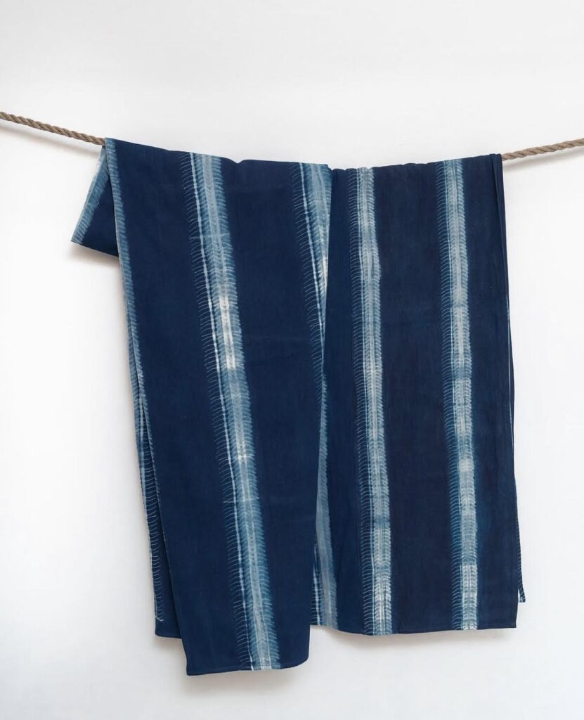 Detail shot of a handwoven Léppi textile, displaying the deep indigo dye and narrow-strip cotton weaving traditional to the Fouta-Djalon region.