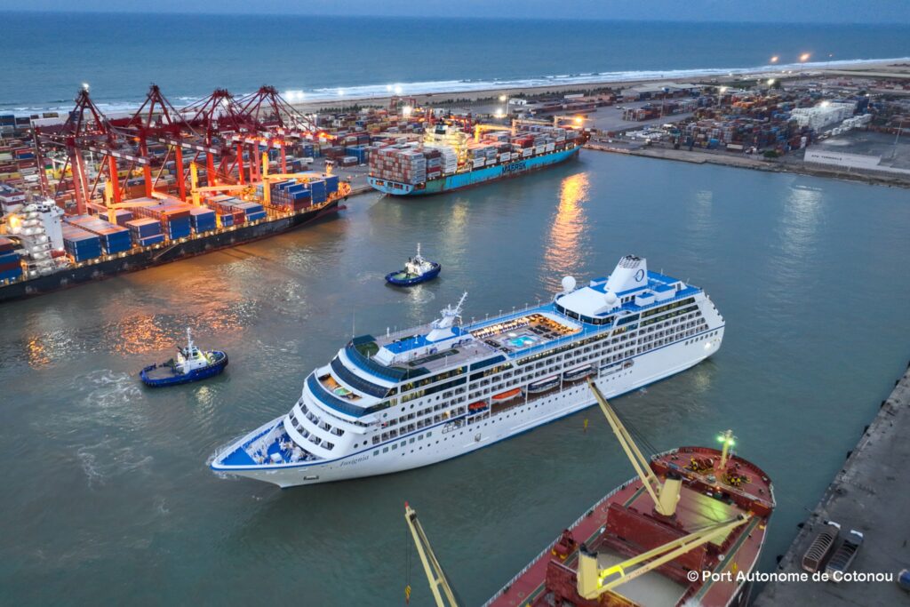 Cotonou Knows Exactly What It's Doing 2 Aerial view of Port Autonome de Cotonou at dusk with a cruise ship, container vessels and cargo cranes along the Benin coastline.