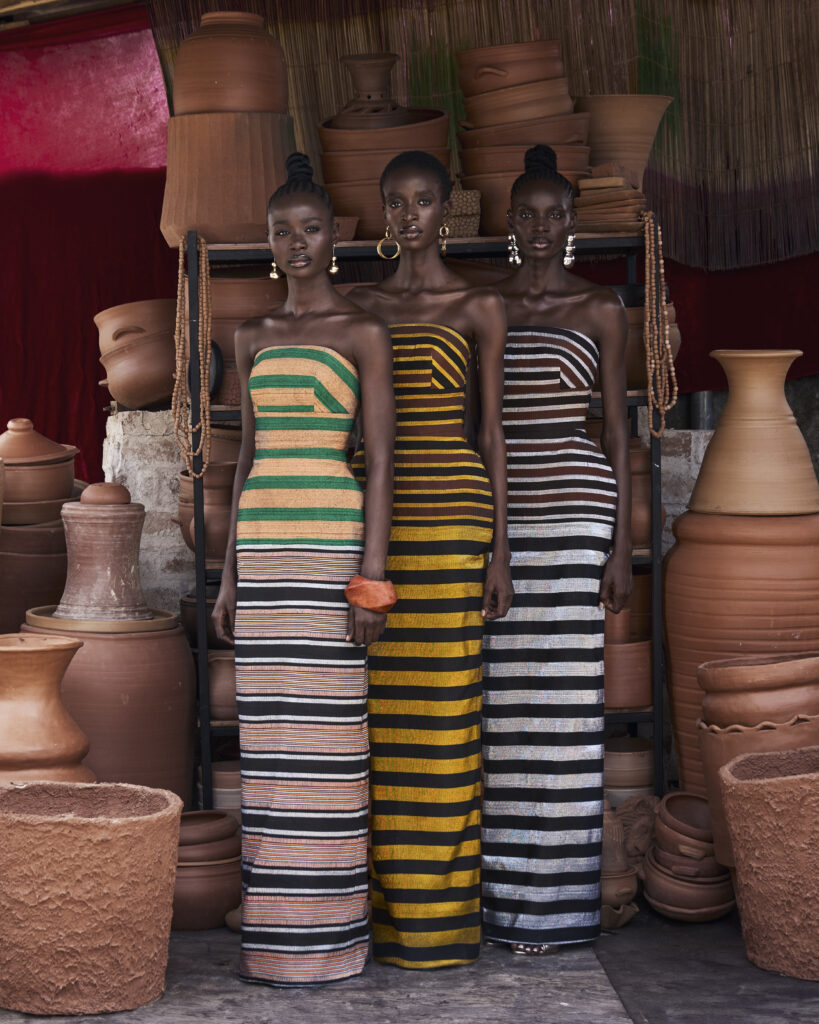 Hertunba's 'Akaoru' Collection Is a Lesson in What Craftsmanship Actually Costs 4 Models wearing hand-woven, boldly striped strapless column dresses from the Hertunba Akaoru collection, set against a pottery studio backdrop.