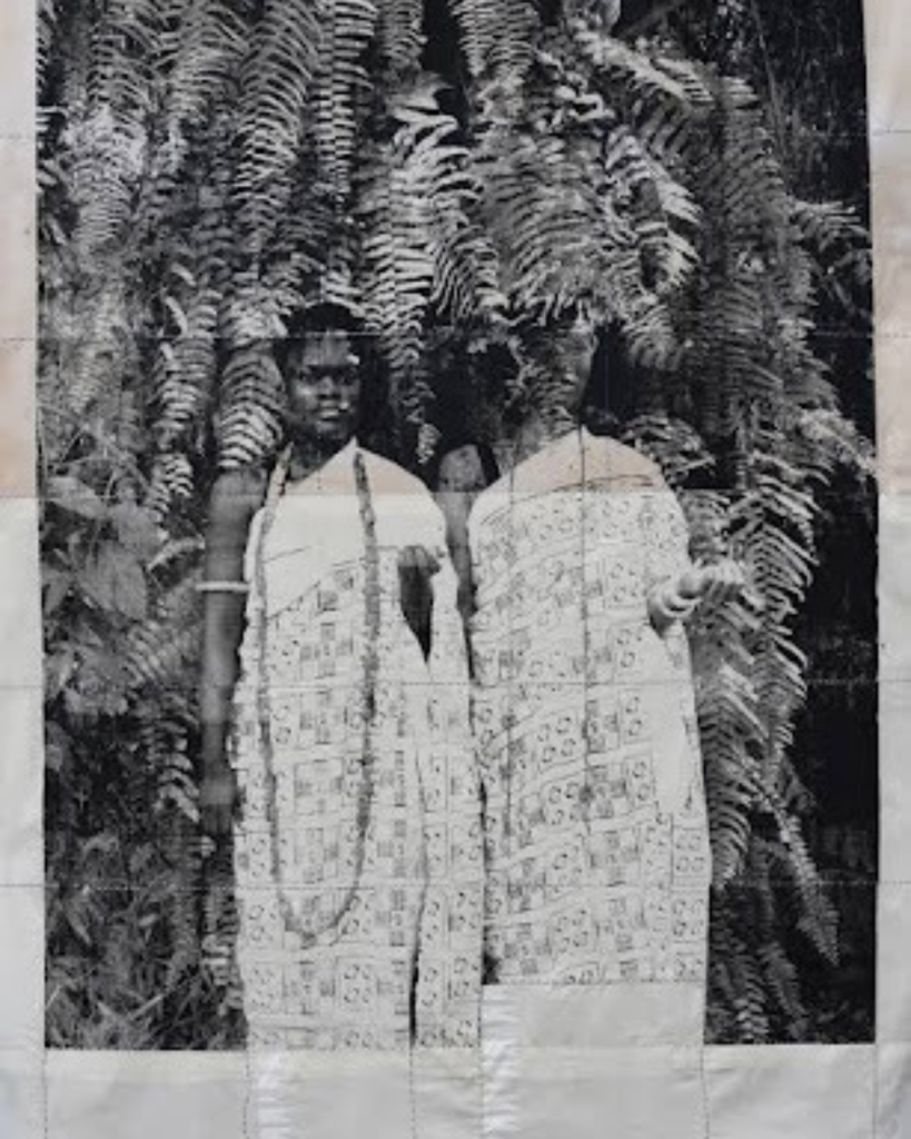Black and white vintage-style portrait of two women wearing patterned textile dresses, highlighting material storytelling in contemporary African art.