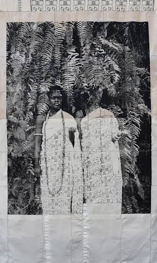 Black and white vintage-style portrait of two women wearing patterned textile dresses, highlighting material storytelling in contemporary African art.