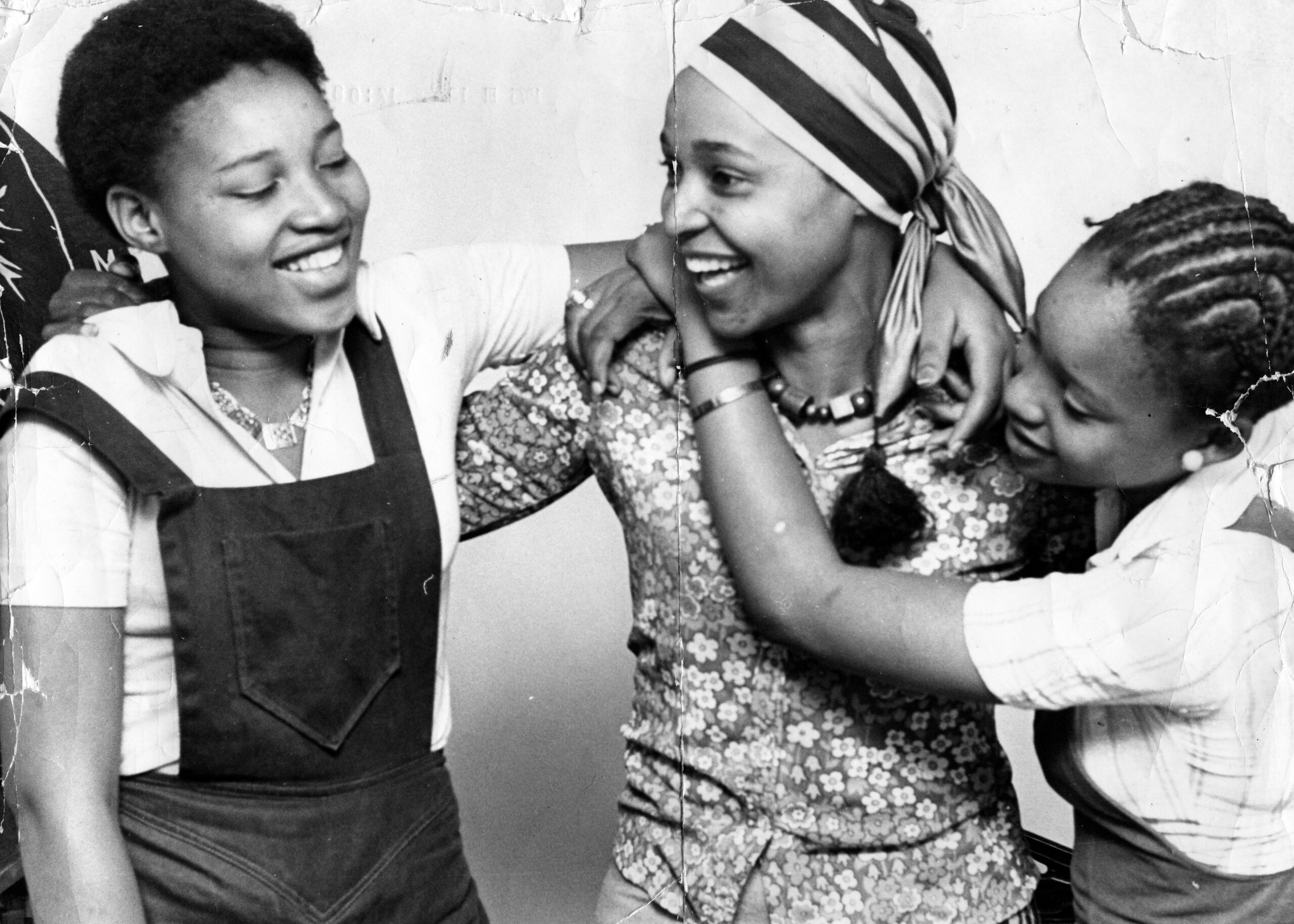The Woman History Could Not Contain 3 Black-and-white archival photograph of a young Winnie Madikizela-Mandela laughing with two other young women.