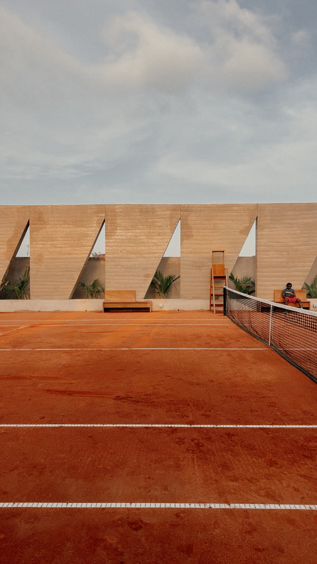Backyard Community Club in Osu, Accra: rammed-earth tennis enclosure by DeRoche Projects