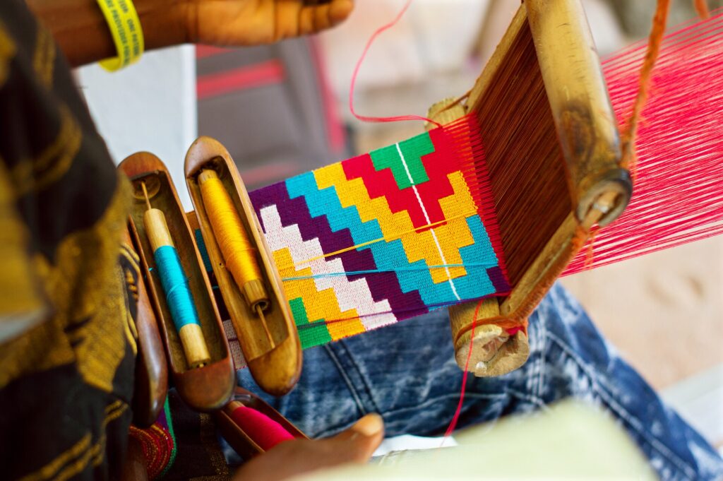 Kente and the Politics of Being Read 1 Kente cloth woven in narrow strips on a horizontal loom in Ghana