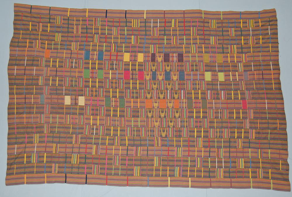 Kente and the Politics of Being Read 3 Ewe kente cloth of narrow striped strips in orange, red, green, and blue, with small inlaid pattern blocks.