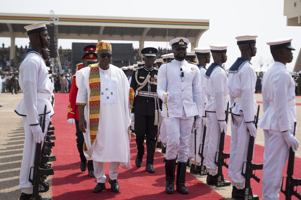 Kente and the Politics of Being Read 5 President Mahama in a white robe and kente stole, holding a silver sword aloft on a red dais at his inauguration.