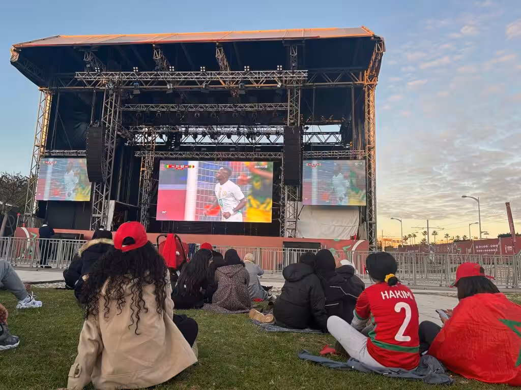 Crowd gathered outdoors watching Senegal play Mali on a large screen during AFCON 2025
