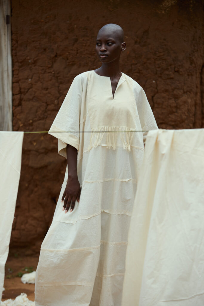 At BAKUS ORAYA, Cotton in Its Final State 10 Look 07 — Indigo Shirt under Long Black Coat.