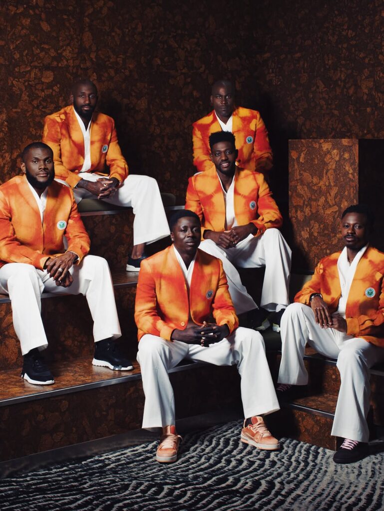 If This. Then That: World Cup Edition — Dressing the Team — Loewe → Ibrahim Fernandez 4 Ibrahim Fernandez ceremonial look for Cote d'Ivoire: men in structured saffron-orange jackets and white trousers, the Elephants' off-pitch World Cup wardrobe.