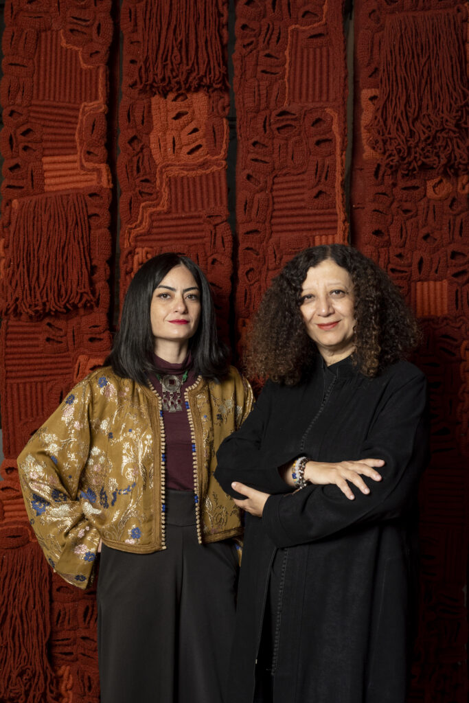 Meriem Berrada Took Morocco to Venice for the First Time 3 Meriem Berrada and Amina Agueznay standing before a large woven textile work at MACAAL in Marrakech. Photo by Matteo Losurdo