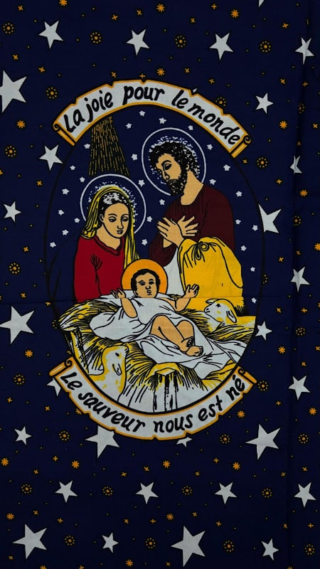 Devotional chitenge with a French-lettered Nativity print reading 'La joie pour le monde', sold for personal wear in Lusaka