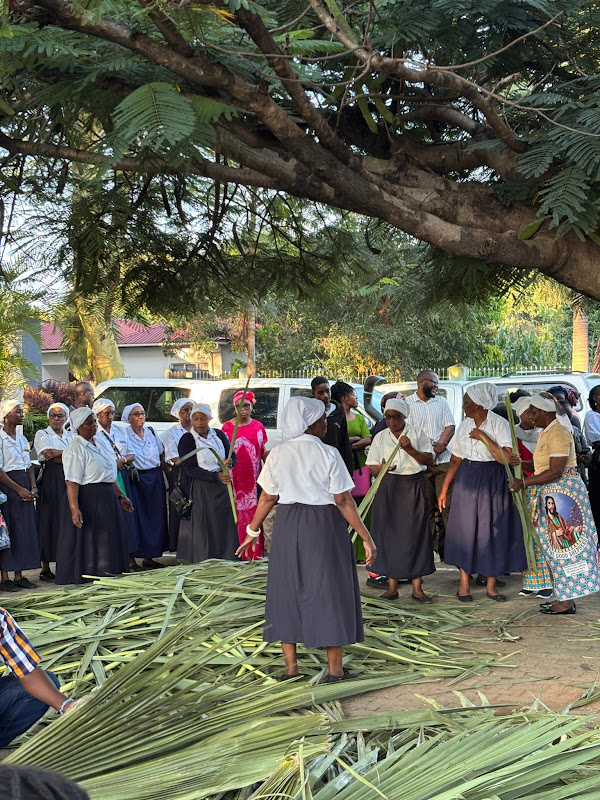 Women in white uniform preparing palm fronds ahead of Palm Sunday at Chelstone Catholic Church, Lusaka