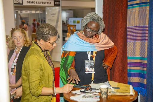 Africa Grows the Cotton. A Dakar Gathering Asks Who Profits. 3 An artisan in conversation with attendees at Africa Sourcing & Fashion Week Dakar 2026