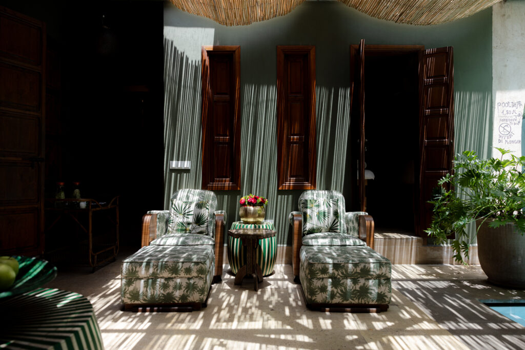 Lounge at El Fenn in Marrakech, with striped curtains in arched niches and low patterned seating on a tiled floor