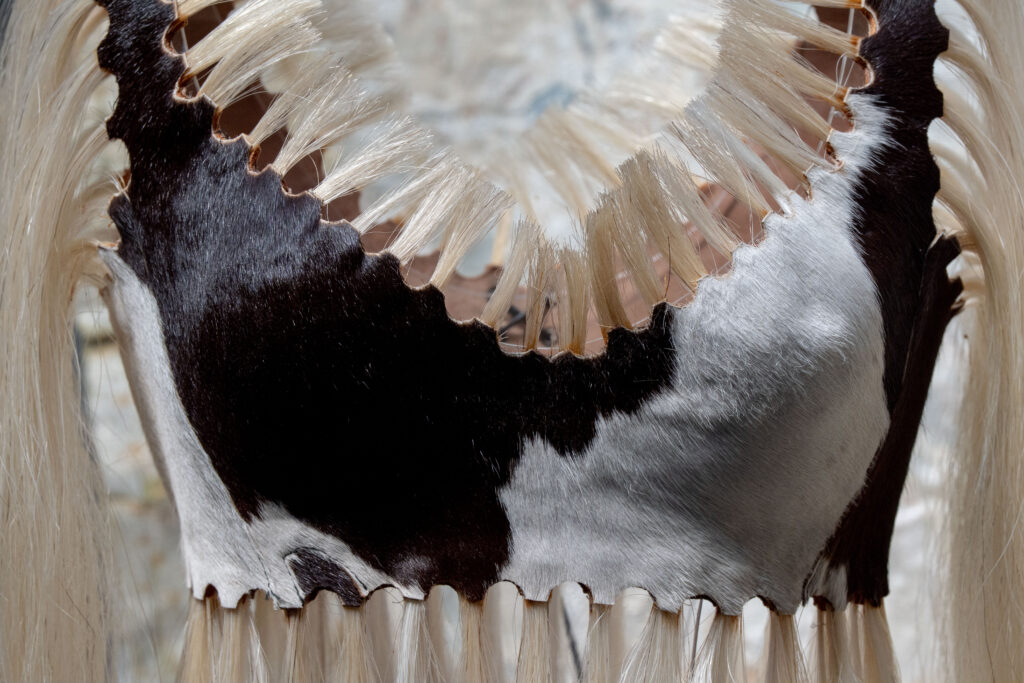 Close-up of an Azzedine Alaïa garment showing the scalloped join where printed hide meets horsehair