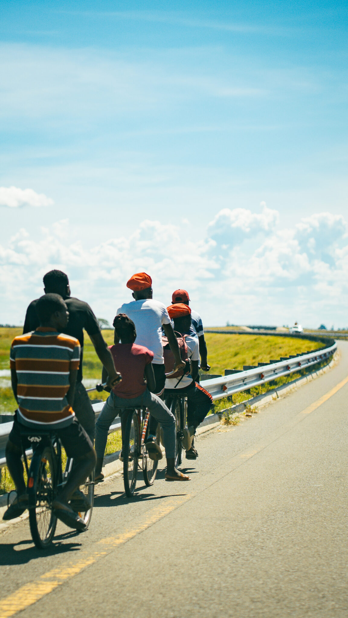 Six Days on the Zambezi: A Traveller's Guide to Kuomboka 1 Men in red Lishushu berets cycle the road toward Mongu, Zambia, in the days before the Kuomboka crossing.