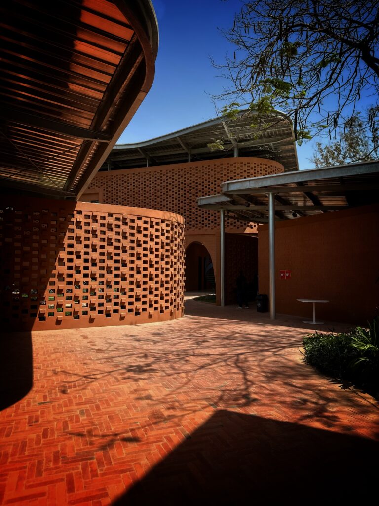 Francis Kéré Builds the Goethe-Institut Dakar from the Ground Up 1 Exterior of the Goethe-Institut Dakar, showing perforated laterite brick walls beneath a steel canopy