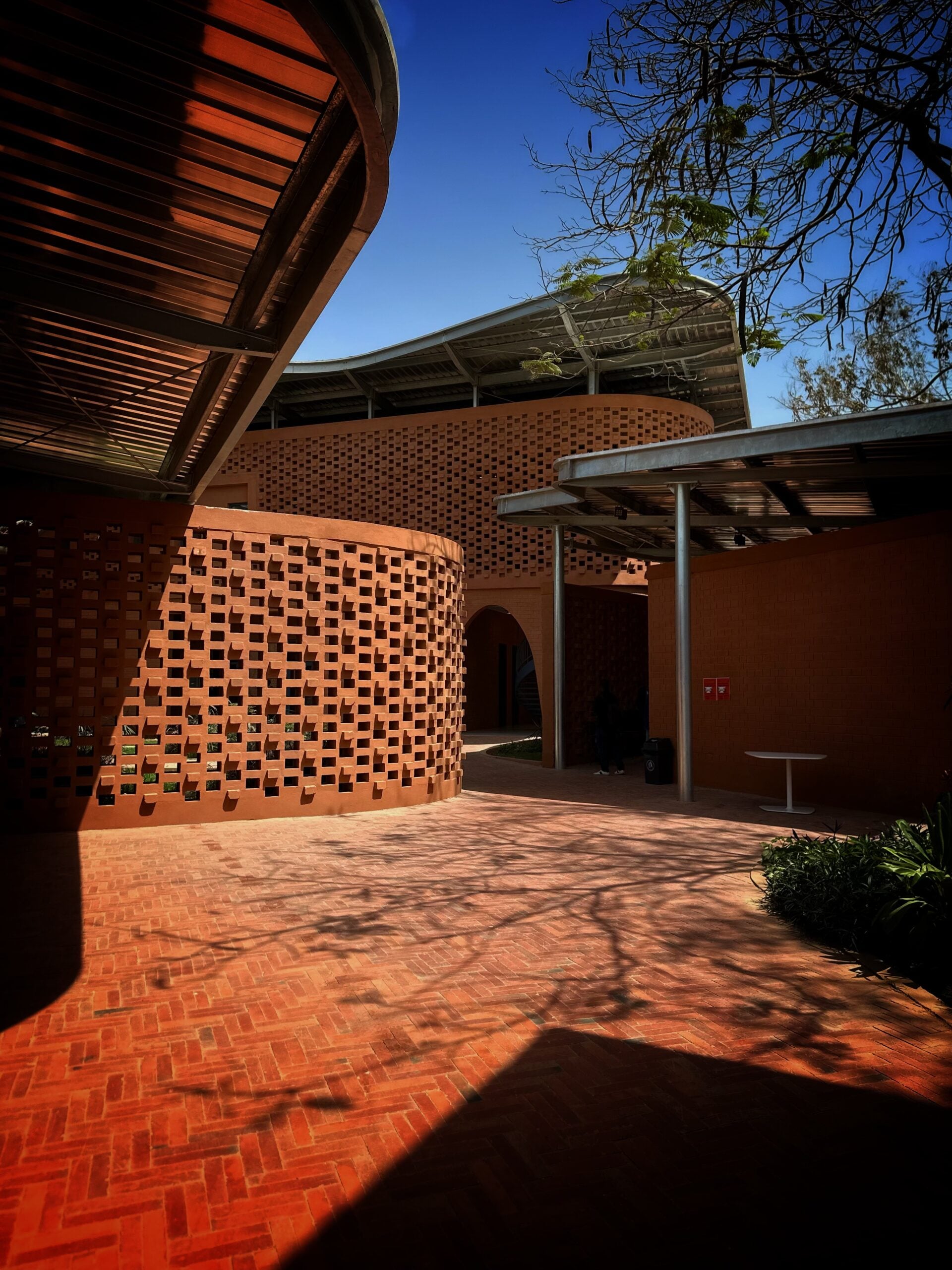 Exterior of the Goethe-Institut Dakar, showing perforated laterite brick walls beneath a steel canopy