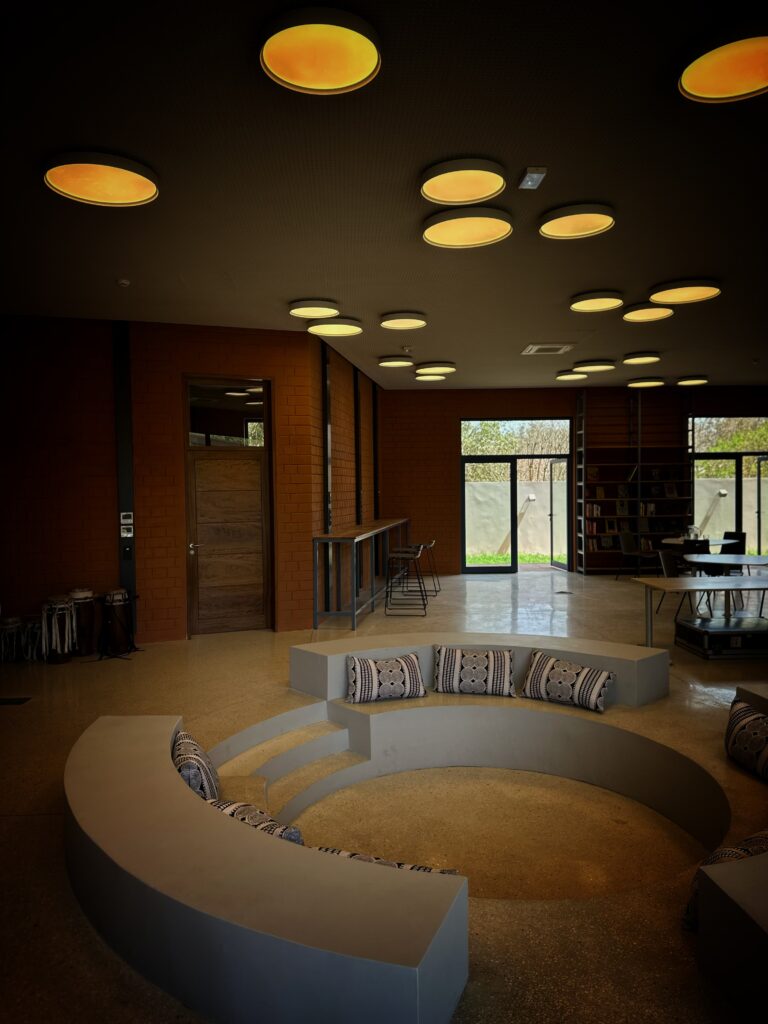 Interior library of the Goethe-Institut Dakar with a circular seating area beneath laterite walls