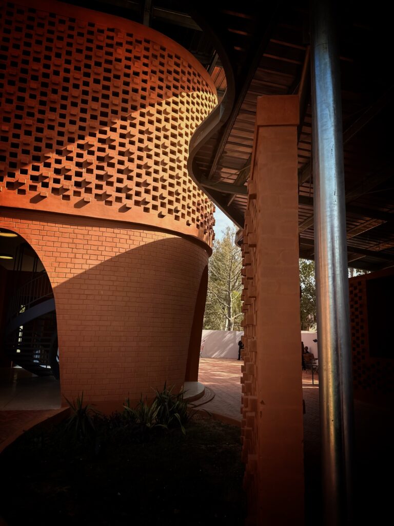 Perforated laterite walls and spaced openings on the exterior of the Goethe-Institut Dakar